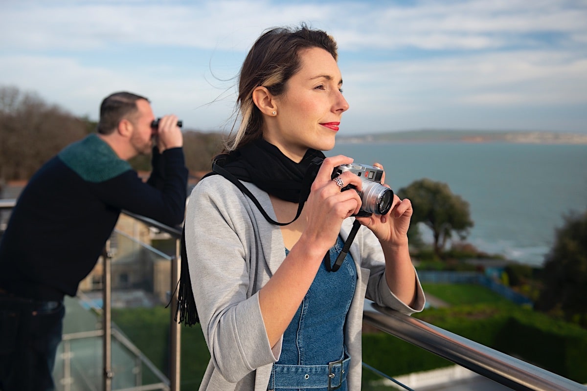 A guest taking in the Isle of Wight coastline from the hotel balcony, camera in hand.